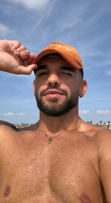 Reel en la playa con gorra naranja